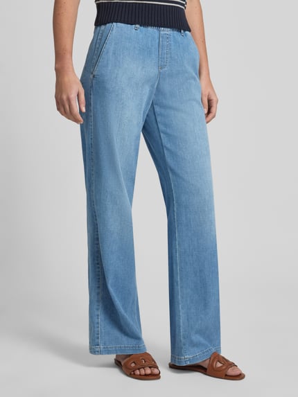 Vrouwenmodel draagt Wide Leg Jeans met elastische band van BRAX, katoenmix met stretch, used-look, lichte denimkleur, detailopname benen.