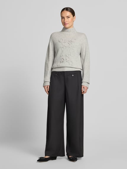Frauenmodel trägt Strickpullover mit Stehkragen von Christian Berg Woman in Hellgrau, lockere Passform, gerippte Abschlüsse, Langarm, Ganzkörperansicht von vorne.