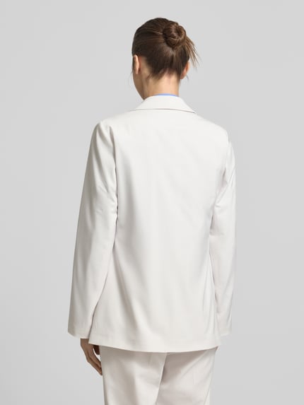 Frauenmodel trägt Slim Fit Blazer mit Pattentaschen von comma aus cremefarbenem Viskose-Mix mit Stretch, Ganzkörperansicht Rückansicht.