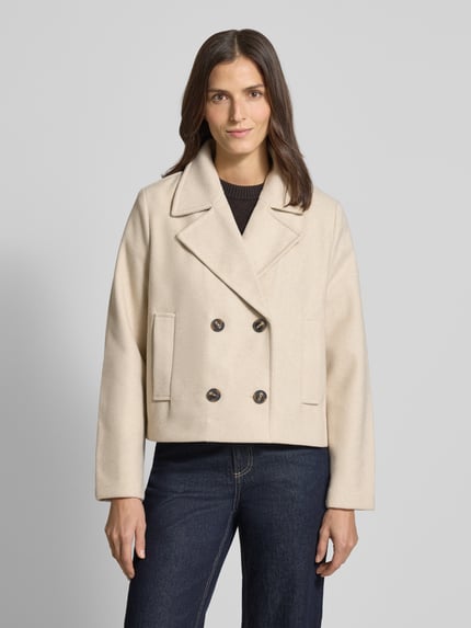 Vrouwenmodel draagt Cropped Trenchcoat met doppelreihige Knopfleiste Model 'VINCEMIA' van Vero Moda, look: effen, boxy fit, reverskraag, lange mouw, zij-steekzakken, korte lengte, voorkant, nahaufnahme oberkörper.