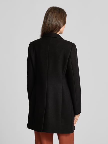 Frauenmodel trägt Regular Fit Mantel mit 2-Knopfleiste von Christian Berg Woman Selection in Schwarz, glatte Textur, Ganzkörperansicht Rückansicht. Taillierte Passform, Reverskragen, Pattentaschen, Rückenlänge 84 cm, Schulterbreite 41 cm, Brustweite 43 cm, Ärmellänge 64 cm.
