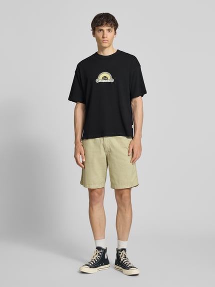 Männermodel trägt T-Shirt mit Label-Print und Rundhalsausschnitt von Jack & Jones in Schwarz, Regular Fit, reine Baumwolle, Ganzkörperansicht von vorne.
