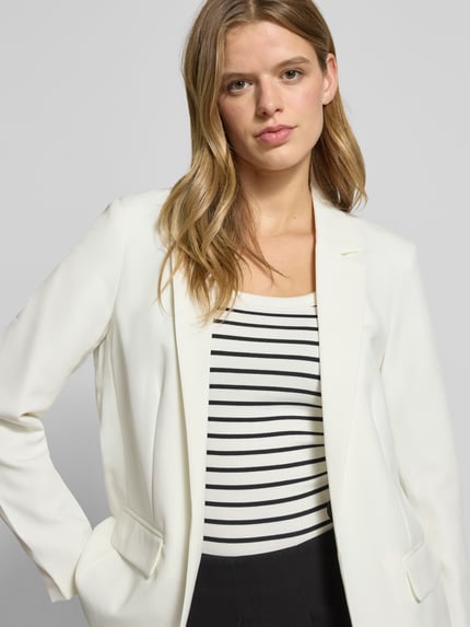 Vrouwenmodel draagt Loose Fit Longblazer met Abnähern Model 'BOZZY' van Pieces in effen kleur met reverskraag, labelstitching, zonder sluiting, lange mouw en klepzakken, look effen, pasvorm loose fit. Nahaufnahme bovenlichaam.