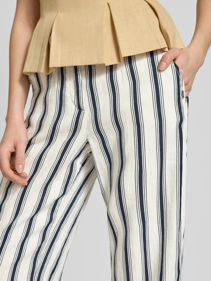Vrouwenmodel draagt Straight Fit Leinenhose in verkürzter Passform van Christian Berg Woman in zuiver linnen, gestreept dessin, knoop- en ritssluiting, bandwijdte maat 36: 39 cm, binnenbeenlengte maat 36: 66 cm, detailopname bovenbeen.
