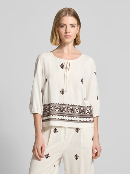 Frauenmodel trägt Bluse aus Viskose-Mix mit 3/4-Arm von Christian Berg Woman Selection, mit Schlüsselloch-Ausschnitt, Straight Fit, cremefarben, Ethno-Muster, Ganzkörperansicht von vorne.