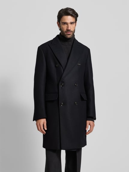 Männermodel trägt Mantel aus Woll-Mix mit Reverskragen Modell 'Richborne' von JOOP! Collection, dunkle Farbe, Gerader-Schnitt, Ganzkörperansicht von vorne. Kontext: Herren Mantel, Stretch-Anteil, Pattentaschen, Knopfverschluss, Zweireiher, Rückenlänge 103 cm, Schulterbreite 47 cm, Brustweite 53 cm, Ärmellänge 67 cm.