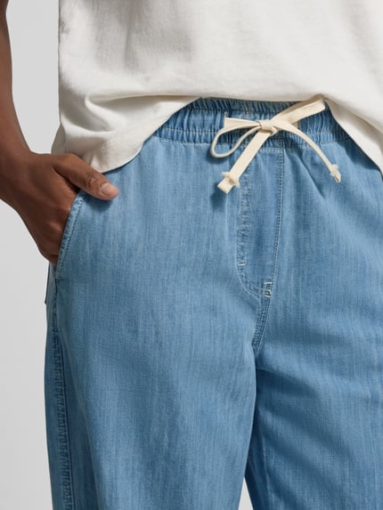 Mężczyznmodel nosi Wide Leg Stoffhose in Denim-Optik od Juvia, spodnie materiałowe z bawełny, krój loose fit, tunel, imitacja denimu, zbliżenie na górną część