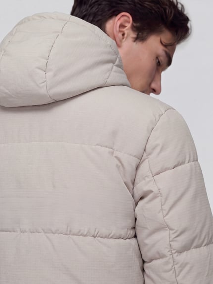 Männermodel trägt Steppjacke mit Kapuze Modell 'SLMVINCENT' von Selected Homme in creme, strukturierte Webware, Detailaufnahme Rückansicht.