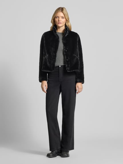 Frauenmodel trägt schwarze Regular Fit Webpelzjacke mit Stehkragen Modell 'NEWVIDA' von ONLY, Damen Teddy- / Webpelzjacke, Ganzkörperansicht von vorne.