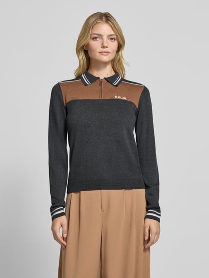 Frauenmodel trägt Slim Fit Strickpullover aus Viskose-Mix mit Kaschmir-Anteil von Karo Kauer, Kołnierzyk polo, Zamek błyskawiczny, Wyhaftowane logo, Długość tyłu w rozmiarze S: 55 cm, Długość rękawów w rozmiarze S: 68 cm, Mieszanka wiskozy z kaszmirem, brązowe i grafitowe bloki kolorów, Ganzkörperansicht von vorne
