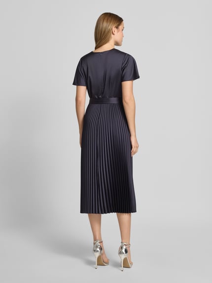 Vrouwenmodel draagt Midikleid aus Satin mit V-Ausschnitt van comma in donkerpaars, getailleerde fit, plissé-look, afneembare stoffen riem, korte mouwen, rugaanzicht volledige lichaamsopname.
