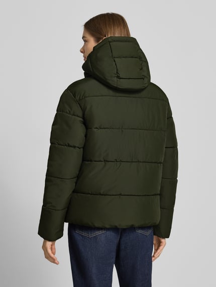 Vrouwenmodel draagt Regular Fit jack in stiksels van Superdry in donkergroen, capuchon met opstaande kraag, afdekstrip, ruglengte maat S 64 cm, schouderbreedte maat S 49 cm, borstwijdte maat S 59 cm, mouwlengte maat S 62 cm, doorgestikte structuur, rechte vormen, gladde textuur, volledig zichtbaar, achteraanzicht.
