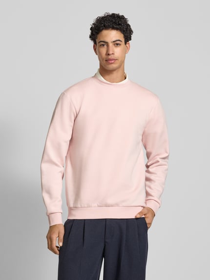 Männermodel trägt Regular Fit Sweatshirt aus Baumwoll-Mix Modell 'CERES' von Only & Sons in Hellrosa, unifarben, Ganzkörperansicht von vorne.