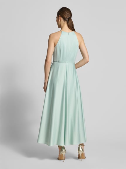 Frauenmodel trägt Cocktailkleid aus Satin mit Bindegürtel von Jake*s Cocktail, hellgrün, A-Linie, Neckholder, Ganzkörperansicht Rückansicht