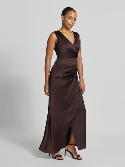 Frauenmodel trägt Abendkleid mit Raffungen von Rinascimento aus braunem Satin mit V-Ausschnitt, ärmellos, Ganzkörperansicht von vorne.