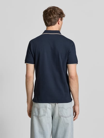 Männermodel trägt dunkelblaues Regular Fit Poloshirt mit Logo-Stitching Modell 'Hedin' von Blend, reine Baumwolle, Rückansicht Ganzkörperansicht.