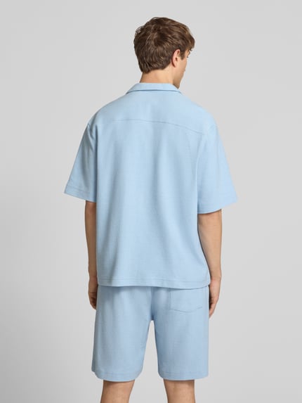 Männermodel trägt Regular Fit Freizeithemd mit Label-Stitching von REVIEW, Baumwoll-Mix, Reverskragen, Brusttasche, hellblau, Ganzkörperansicht Rückansicht.