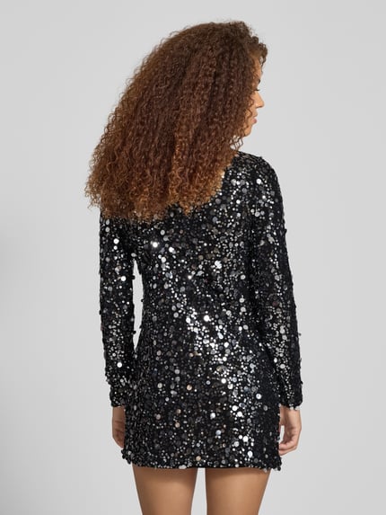 Frauenmodel trägt Fließendes Abendkleid mit Paillettenbesatz Modell 'ANIKA CATINA' von Only in glänzender, schwarzer Mesh-Optik, Mini-Länge, langarm, Rundhals, mit geradem Saum, Ganzkörperansicht Rückansicht.