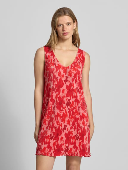Frauenmodel trägt Fließendes Freizeitkleid mit Allover-Muster von Pieces in Rot mit V-Ausschnitt, breite Träger, Plissee, Mini-Länge, Ganzkörperansicht von vorne.