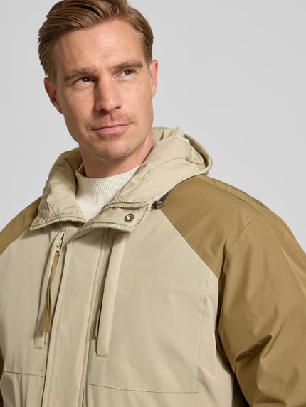 Männermodel draagt Jacke met kapuze Modell 'Lao' van WOODBIRD, beige-bruin kleur, katoenmix, regular fit, Nahaufnahme bovenlichaam.