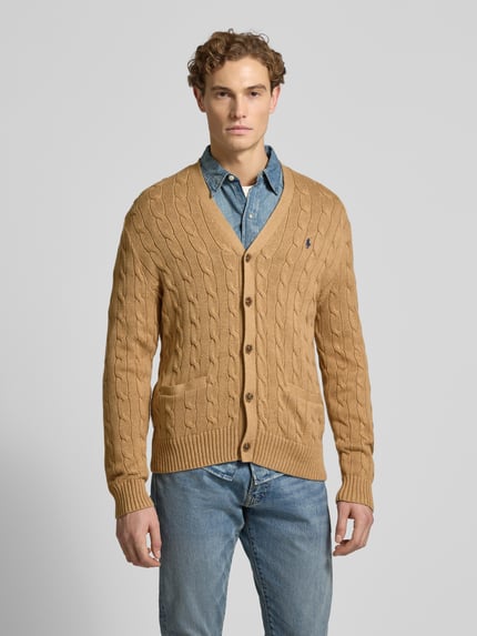 Mannelijk model draagt Strickjacke mit Knopfleiste van Polo Ralph Lauren, beige kabelbreisel, regular fit, geribde boorden, voorkant, volledige lichaamsweergave.