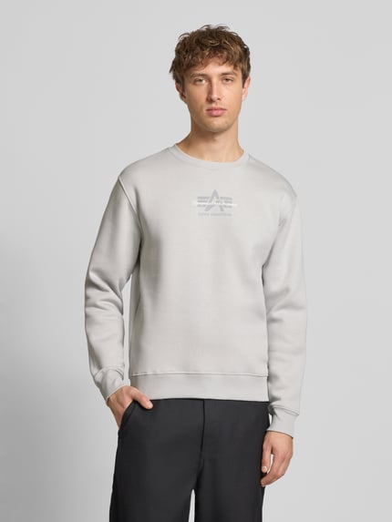 Männermodel trägt Regular Fit Sweatshirt aus Baumwoll-Mix mit Label-Detail von Alpha Industries, hellgrau, elastische Abschlüsse, Ganzkörperansicht von vorne, Rückenlänge bei Größe M 66 cm