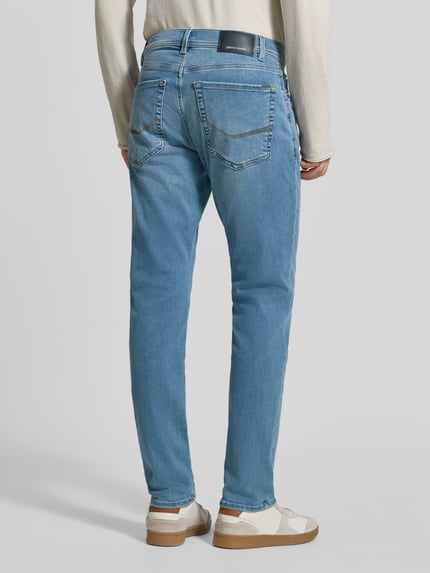 Männermodel trägt Regular Fit Jeans im 5-Pocket-Design Modell 'Lyon' von Pierre Cardin in Hellblau, elastischer Baumwoll-Mix, Ganzkörperansicht Rückansicht. Herren Jeans, Lyocell-Anteil, Knopf- und Reißverschluss, Bundweite 41 cm, Innenbeinlänge 79 cm.