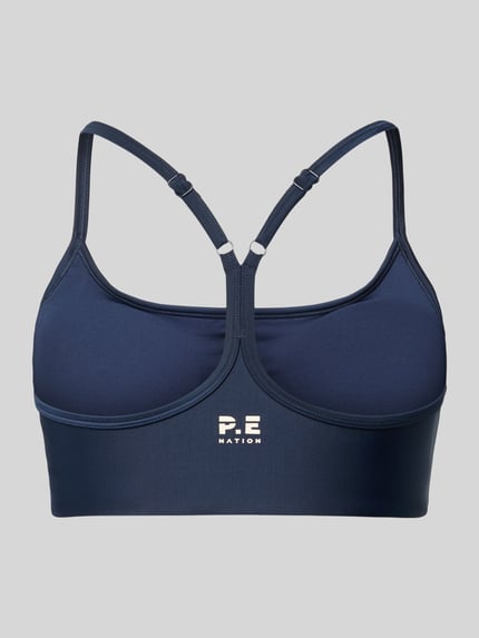 Produktfoto, dunkelblauer Sport-BH mit Racerback und Logo-Print, glatte Textur, Modell 'ACTIVE' von P.E Nation, Stretch-Material-Mix