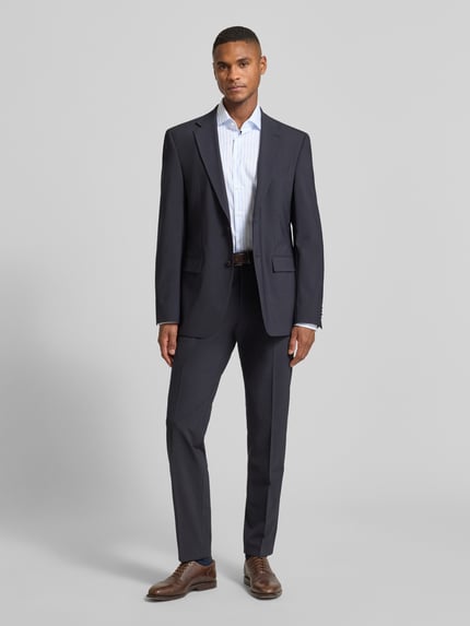Männermodel trägt Slim Fit Business Hemd aus Baumwolle mit Kentkragen von SEIDENSTICKER, helle Farbe, dezentes Streifenmuster, kombiniert mit Anzug, Knopfleiste sichtbar, Ganzkörperansicht von vorne.