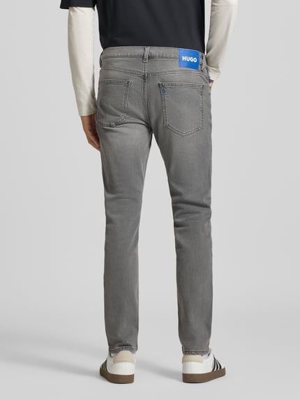 Mannelijk model draagt grijze slim jeans met vijf zakken, effen structuur, Super Slim Fit Jeans uit katoenmix model 'Zane' van HUGO Blue, Ganzkörperansicht Rückansicht.