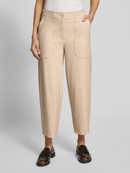 Vrouwenmodel draagt Barrel Fit Stoffhose met Eingrifftaschen Modell 'Myha fresh' van OPUS in beige, detailopname voorkant. Mix van viscose, steekzakken, knoop- en ritssluiting, maat 36: taille 40 cm, binnenbeen 64 cm.