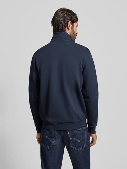 Männermodel trägt Regular Fit Blouson aus Baumwoll-Mix von Tommy Hilfiger in Dunkelblau, Stehkragen, langarm, Rippenbündchen, Ganzkörperansicht Rückansicht.