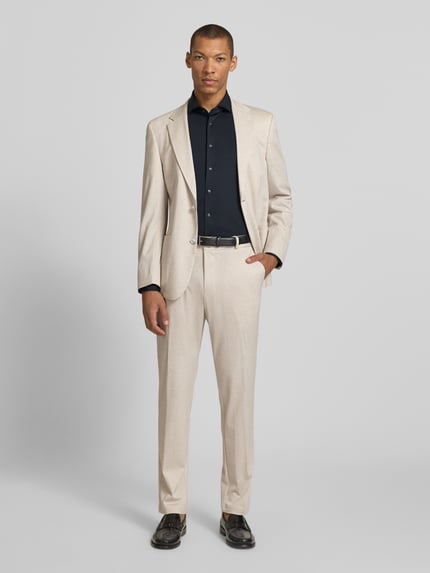 Männermodel trägt Slim Fit Business-Hemd mit Haifischkragen von SEIDENSTICKER, Material-Mix mit Stretch-Anteil, Knopfleiste, schwarze Farbe, Ganzkörperansicht von vorne.