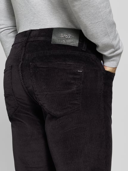 Männermodel trägt schwarze Straight Fit Cordhose aus Baumwoll-Mix Modell 'Mythos Flex Cord' von Brax, Detailaufnahme Rückansicht, Herren Cordhose von Brax.