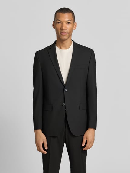 Männermodel trägt schwarzen Anzug mit Reverskragen und Bügelfalte von HECHTER PARIS, Material-Mix, Regular-Fit, Ganzkörperansicht von vorne.