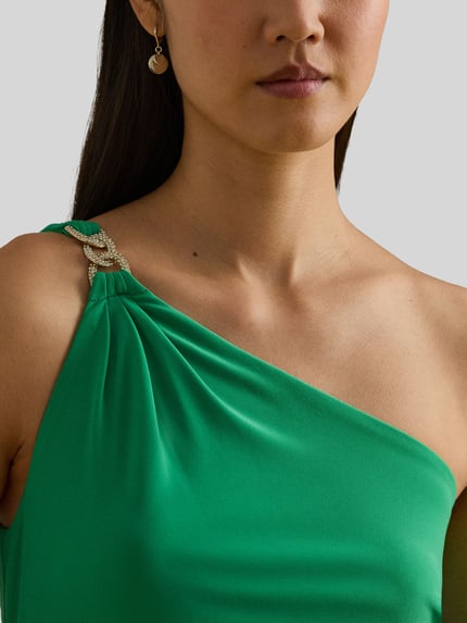 Frauenmodel trägt Abendkleid im One-Shoulder-Look Modell 'BELINA' von Lauren Ralph Lauren in kräftigem Grün mit Ziersteinbesatz, Nahaufnahme Oberkörper. Material-Mix mit Stretch, figurbetonter Schnitt, Kontext: Maxikleid, Rückenlänge 149 cm, Brustweite 37 cm bei Größe 36.