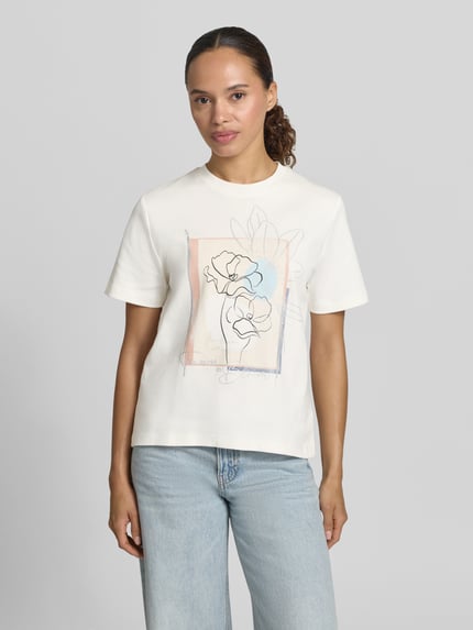 Modelka kobieca ma na sobie damski t-shirt z bawełny, krój regular fit, okrągły dekolt, nadruk z motywem, T-Shirt mit Rundhalsausschnitt und Motiv-Print von Christian Berg Woman, długość tyłu w rozmiarze S: 55 cm, jasne kolory, prosta faktura, całkowity widok z przodu.