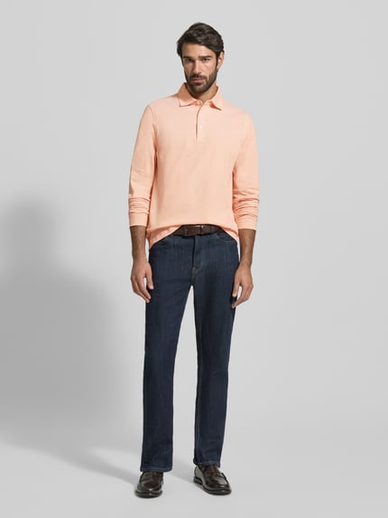Männermodel trägt Regular Fit Poloshirt mit Knopfleiste von MAERZ Muenchen aus reiner Baumwolle, Longsleeve, Ganzkörperansicht von vorne.