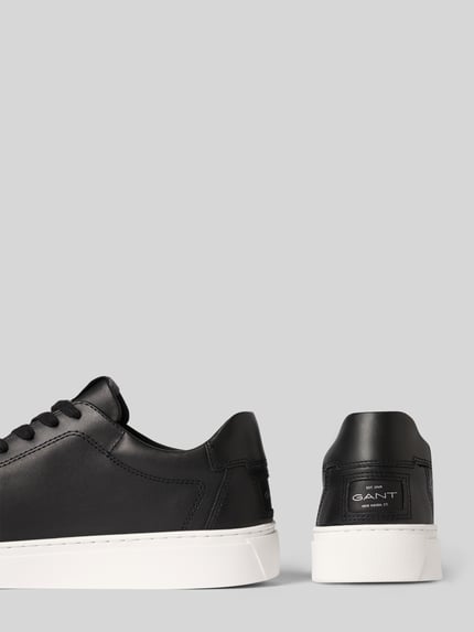 Produktfoto, Sneaker aus echtem Leder Modell 'Julien' von Gant in Schwarz mit weißer profilierter Sohle, abgerundete Form, Logo-Prägung, Schnürverschluss, neutrale Hintergrundfarbe, abgesetzte Kanten, strukturierte Textur, Absatzhöhe 3 cm, Schafthöhe 8 cm, Schaftweite 9 cm.