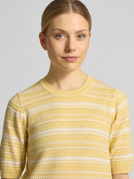 Vrouwenmodel draagt gebreide pullover uit katoenmix van Scotch & Soda, getailleerd, ronde hals, tricotlook, 3/4-mouw, Nahaufnahme Oberkörper.