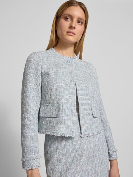 Frauenmodel trägt Regular Fit Blazer in Bouclé-Optik von Marc Cain aus Baumwoll-Mix mit Pattentaschen, Rundhalsausschnitt, Nahaufnahme Oberkörper.