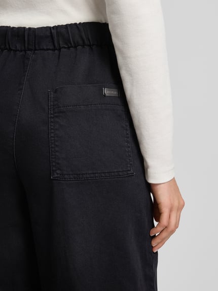 Frauenmodel trägt Jeans mit elastischem Bund von MAC, dunkler Baumwoll-Mix mit Tunnelzug, lockerer Schnitt, Nahaufnahme Rückansicht.