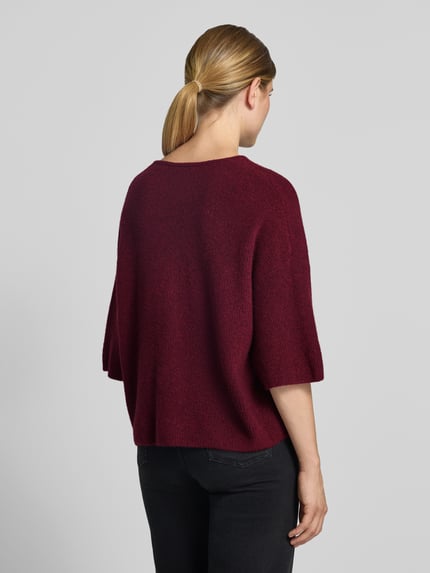 Frauenmodel trägt Oversized Strickpullover mit Leinen-Anteil von American Vintage in Dunkelrot, grobe Struktur, Rückenansicht, Ganzkörperansicht Rückansicht. Damen Strickpullover, Material-Mix mit Leinen-Anteil, Oversized Fit, Rundhalsausschnitt, überschnittene Schultern, Halbarm, gerippt, Rückenlänge 50 cm, Ärmellänge 54 cm.