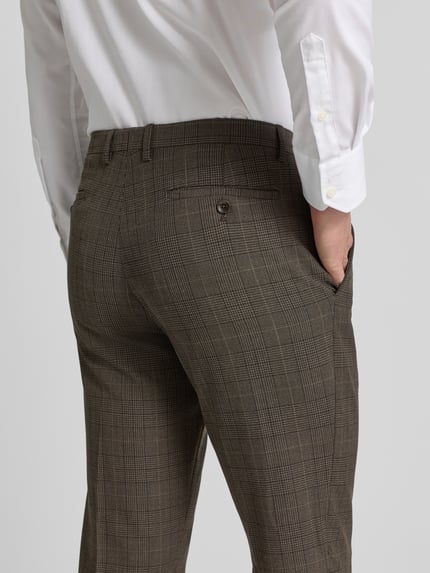 Mannenmodel draagt stoffen broek met bandplooien, steekzakken, achterzakken, materiaalmix met viscose van MCNEAL, detailopname achterkant.