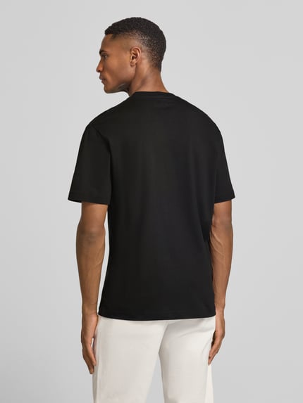 Männermodel trägt Regular Fit T-Shirt aus reiner Baumwolle von Lacoste, Optik: Unifarben, Ganzkörperansicht Rückansicht.