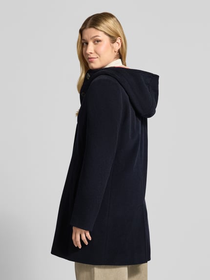Frauenmodel trägt Wollmantel mit Kapuze von GIL BRET, unifarben, strukturierte Webware, lange Ärmel, Label-Detail, Ganzkörperansicht Rückansicht.