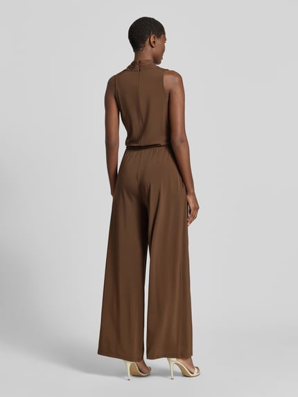 Frauenmodel trägt Jumpsuit aus Viskose-Mix Modell 'TROPICO' von Weekend Max Mara in Braun, unifarben, mit Bindegürtel und Gürtelschlaufen, Ganzkörperansicht Rückansicht.
