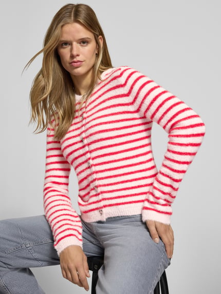 Frauenmodel trägt Strickjacke mit Herzknöpfen von ONLY in Weiß und Pink mit Streifenmuster, weiche Textur, Nahaufnahme Oberkörper.