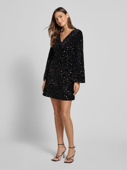 Frauenmodel trägt Minikleid mit Pailletten Modell 'BARINA' von Vila, A-Linie, V-Ausschnitt, schwarz glänzend, Ganzkörperansicht von vorne.