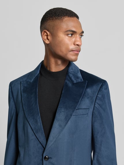 Männermodel trägt 2-Knopf-Sakko mit Reverskragen von Christian Berg Men, samtig blaue Oberfläche, schwarze Knöpfe, Nahaufnahme Oberkörper.